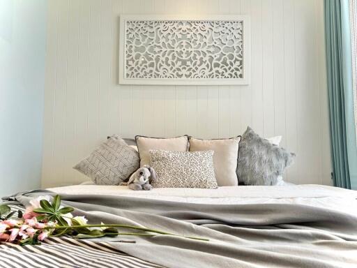 Cozy bedroom interior with decorative pillows and a plush toy on the bed