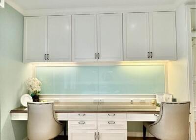Modern kitchen with white cabinetry and seating area