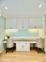 Modern kitchen with white cabinetry and seating area