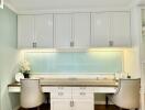 Modern kitchen with white cabinetry and seating area