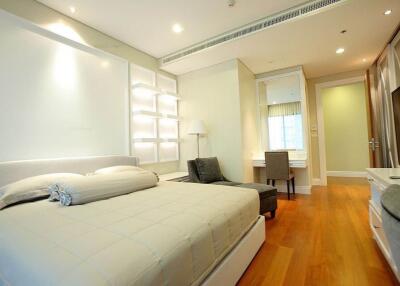 Spacious bedroom with modern design, hardwood floors, and ample lighting