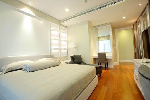 Spacious bedroom with modern design, hardwood floors, and ample lighting