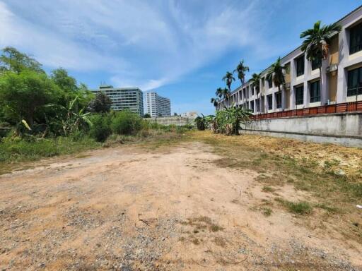 Empty urban lot with surrounding buildings under a clear sky