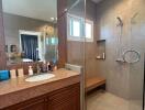 Modern bathroom interior with marble countertop and glass shower