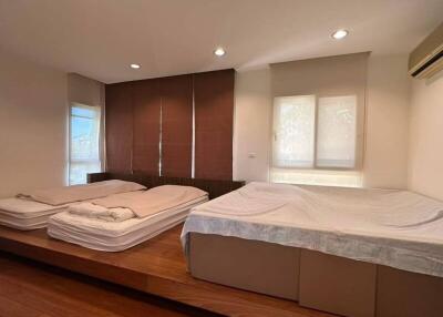 Spacious bedroom with twin beds and modern wooden wall paneling