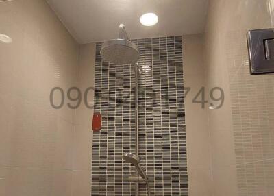 Modern bathroom interior with glass shower and tiled wall