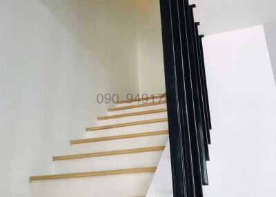 Modern staircase with wooden steps and black metal railing