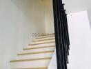 Modern staircase with wooden steps and black metal railing