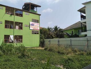 Green outdoor area with a multi-story building in the background