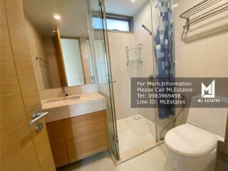 Modern bathroom with glass shower enclosure and wooden vanity