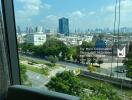 City view from a high-rise building window, showcasing a busy intersection and skyline