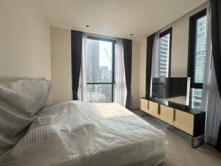 Modern bedroom interior with city view through large windows