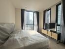 Modern bedroom interior with city view through large windows