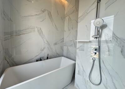 Modern bathroom with marble tiles and standalone bathtub