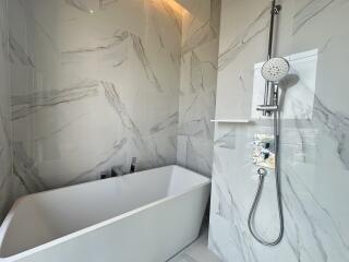 Modern bathroom with marble tiles and standalone bathtub