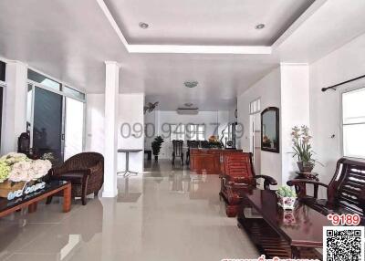 Spacious and well-lit living room with comfortable seating and decorative plants