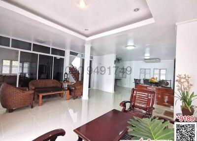 Spacious living room with natural light, comfortable seating and dining area