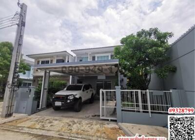 Modern two-story house with carport and vehicle