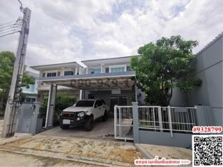 Modern two-story house with carport and vehicle