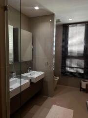 Modern bathroom with a glass shower, double sink, and large mirror