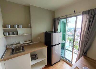 Compact kitchen space with modern appliances and balcony access