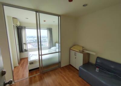 Compact bedroom with sliding glass door, balcony access, and city view