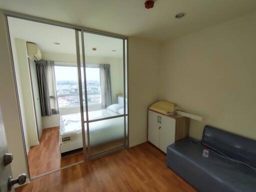 Compact bedroom with sliding glass door, balcony access, and city view