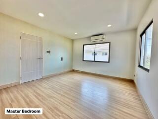 Spacious master bedroom with air conditioning and ample natural light