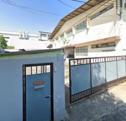 Exterior view of a two-story building with a secure entrance gate