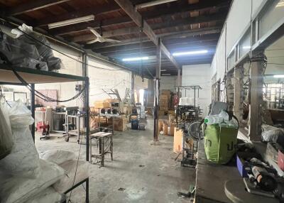 Spacious industrial warehouse interior with storage items and machinery