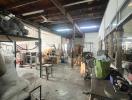 Spacious industrial warehouse interior with storage items and machinery