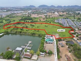Aerial view of a spacious property with marked boundary next to a lake and residential area