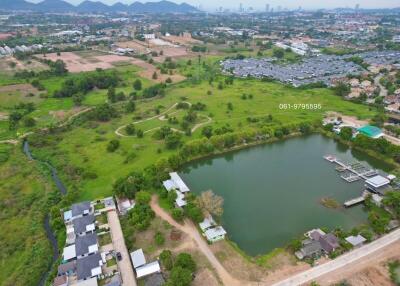 Aerial view of a residential area with a pond and green landscaping