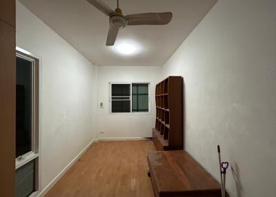 Empty bedroom with wooden flooring and a ceiling fan