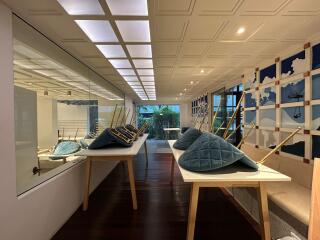 Modern hallway with exhibition setup showing models of ships and various artistic pieces