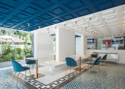 Modern indoor lounge with blue chairs and artistic ceiling design