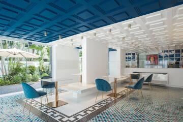 Modern indoor lounge with blue chairs and artistic ceiling design