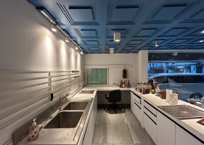 Modern kitchen with stainless steel appliances and geometric ceiling design