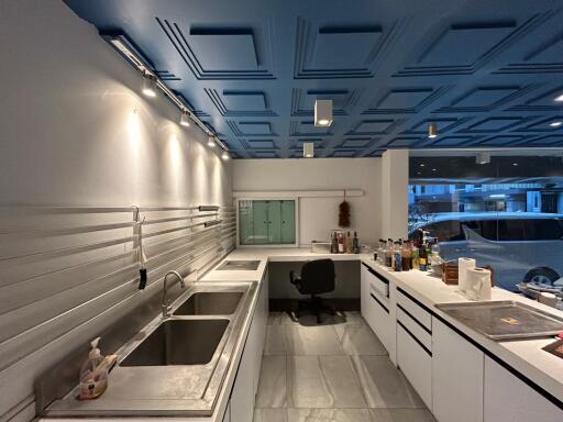 Modern kitchen with stainless steel appliances and geometric ceiling design