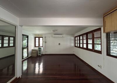 Spacious and empty living room with hardwood floors and large windows