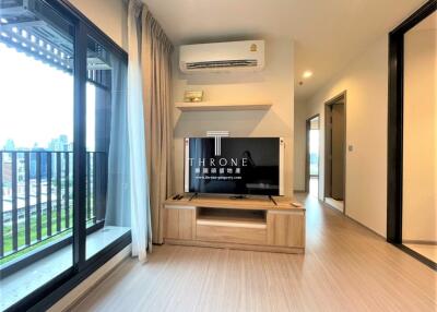 Spacious living room with modern furnishings, large window and balcony access