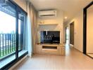 Spacious living room with modern furnishings, large window and balcony access