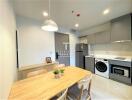 Modern kitchen with dining area, stainless steel appliances, and ample cabinet space