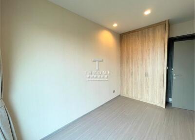 Empty bedroom with wooden wardrobe and modern lighting