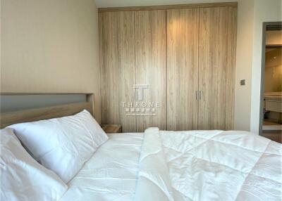 Modern bedroom interior with large bed and wooden wardrobe