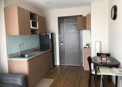 Modern kitchen with stainless steel appliances and wooden cabinets in a compact living space