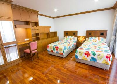 Spacious bedroom with twin beds and wooden flooring