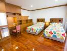 Spacious bedroom with twin beds and wooden flooring