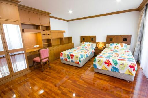 Spacious bedroom with twin beds and wooden flooring