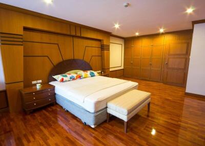 Spacious bedroom with wooden floor and ample wardrobes
